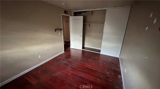 unfurnished bedroom with hardwood / wood-style flooring and a closet