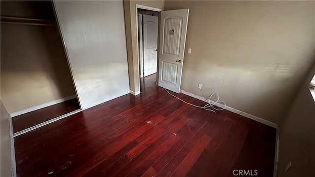 unfurnished bedroom with wood-type flooring and a closet