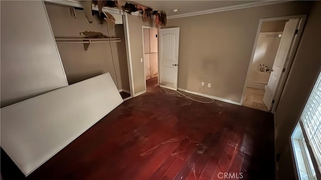 unfurnished bedroom with crown molding, a closet, and hardwood / wood-style flooring