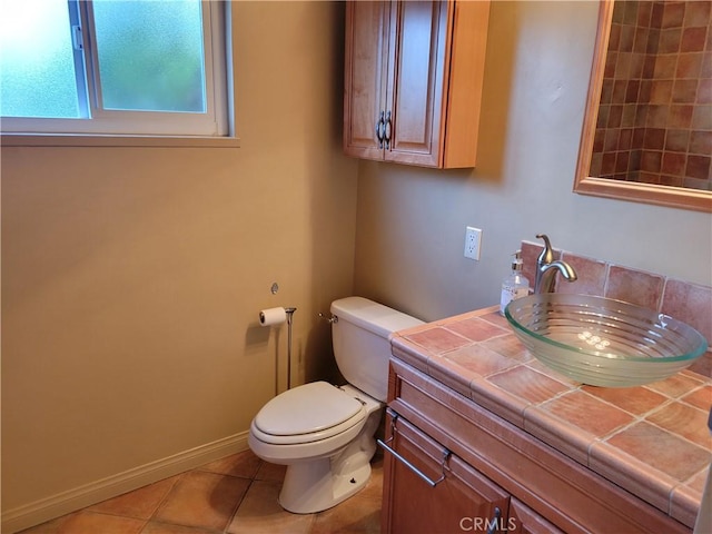 bathroom with tile patterned flooring, vanity, and toilet