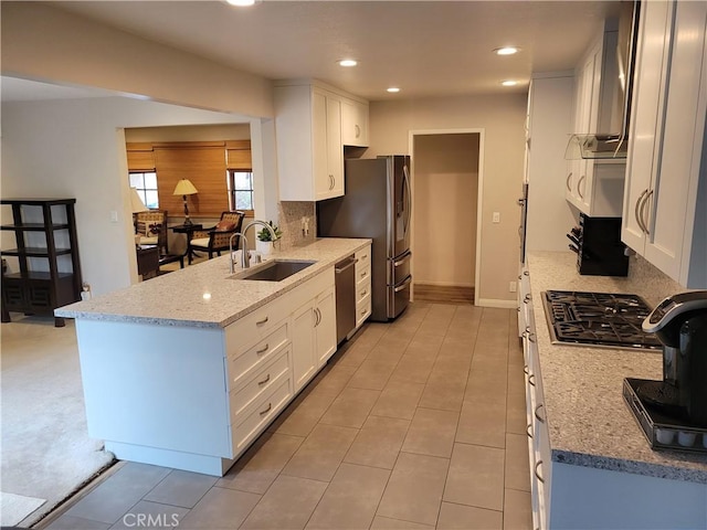 kitchen featuring sink, light stone countertops, white cabinets, and appliances with stainless steel finishes