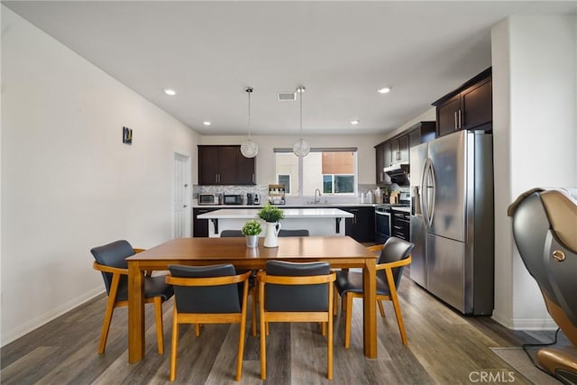 dining space featuring dark wood-type flooring and sink