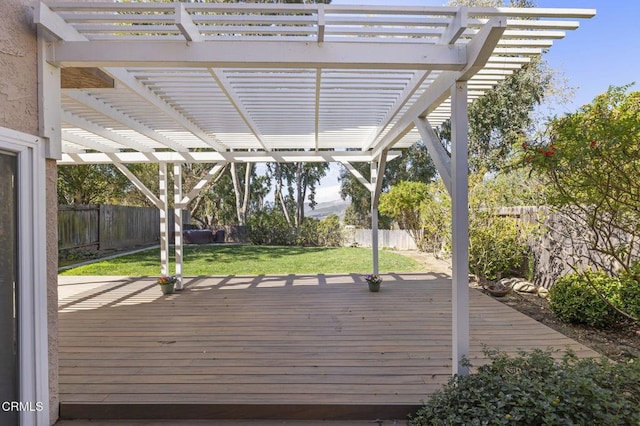 wooden terrace featuring a fenced backyard, a lawn, and a pergola