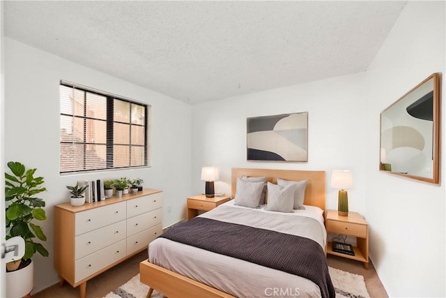 bedroom featuring light colored carpet and a textured ceiling