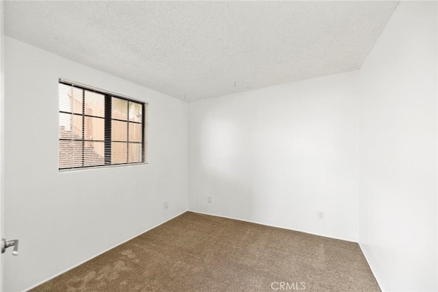 carpeted empty room with a textured ceiling