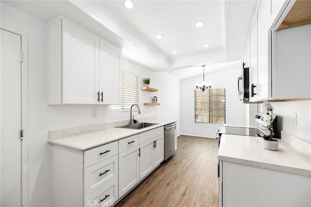 kitchen with white cabinetry, sink, decorative light fixtures, and stainless steel appliances