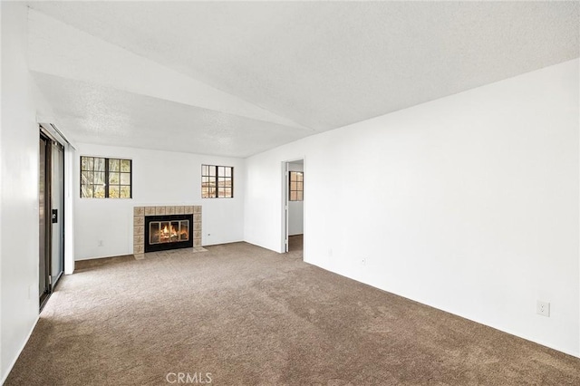 unfurnished living room featuring a fireplace, carpet floors, and a textured ceiling