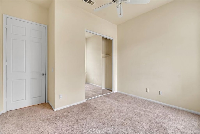 unfurnished bedroom with light carpet, a closet, and ceiling fan