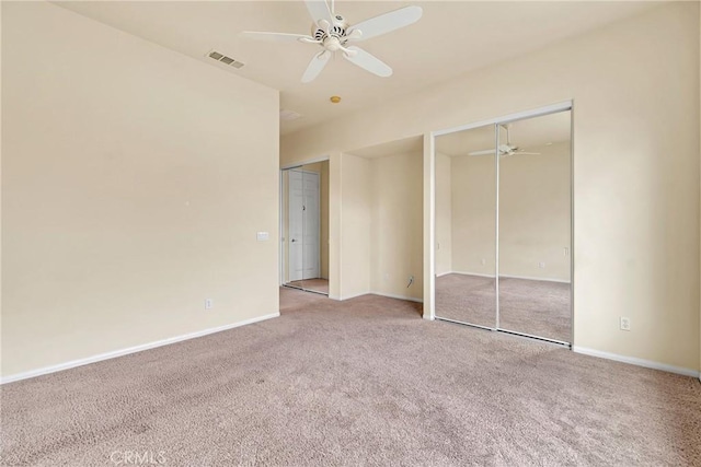 unfurnished bedroom with multiple closets, light carpet, and ceiling fan