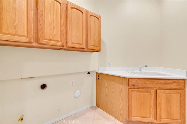 washroom featuring cabinets, gas dryer hookup, sink, and light tile patterned flooring