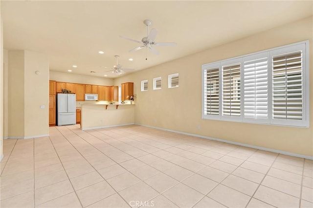 unfurnished living room featuring ceiling fan and light tile patterned floors