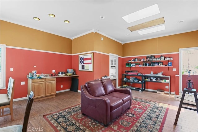 living room with crown molding, a skylight, and hardwood / wood-style floors