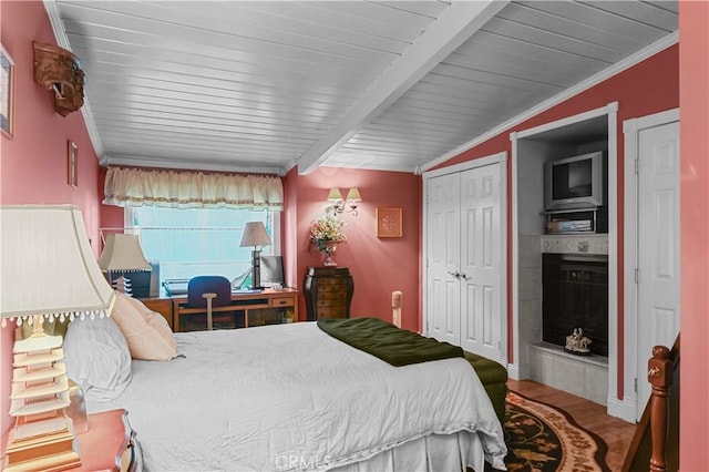 bedroom featuring crown molding, vaulted ceiling with beams, wood ceiling, and a closet