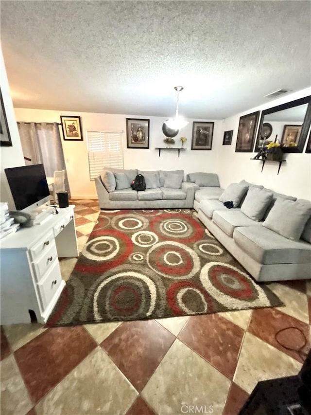 living area with visible vents, a textured ceiling, and light tile patterned flooring