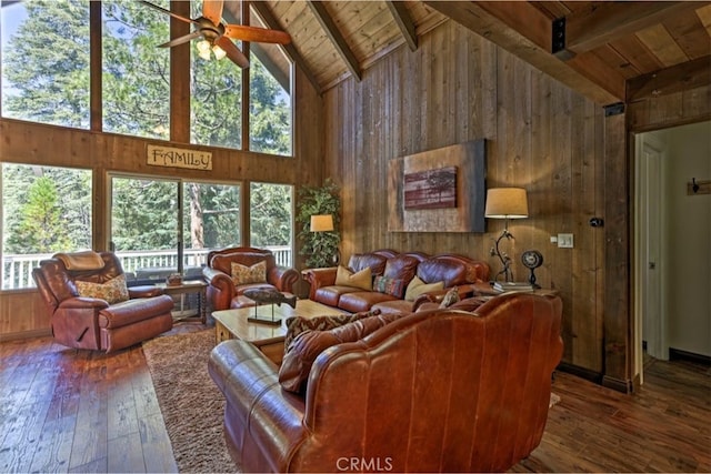 living room featuring vaulted ceiling with beams, hardwood / wood-style floors, wooden ceiling, and wood walls