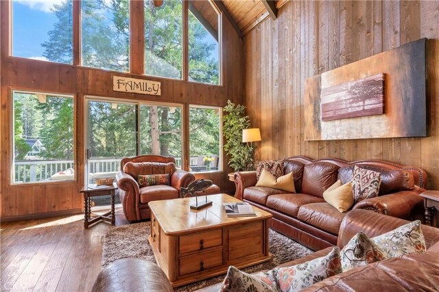 26619 Bel Air Ct, Lake Arrowhead, CA 92352 - living room featuring wood walls, hardwood / wood-style floors, plenty of natural light, high vaulted ceiling, and beam ceiling