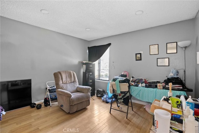 home office featuring light hardwood / wood-style flooring and a textured ceiling