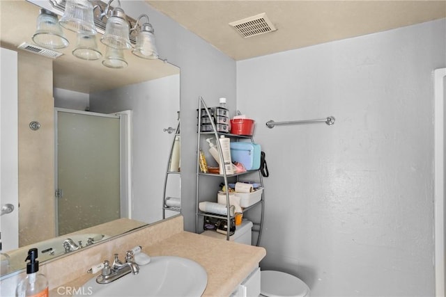 bathroom featuring vanity, a shower with door, and toilet