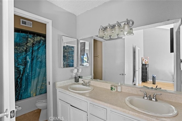 full bathroom with vanity, shower / bath combination with curtain, a textured ceiling, and toilet