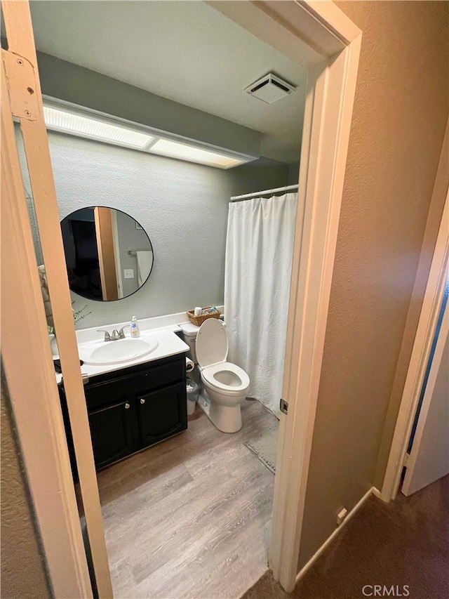 bathroom with vanity, hardwood / wood-style floors, and toilet