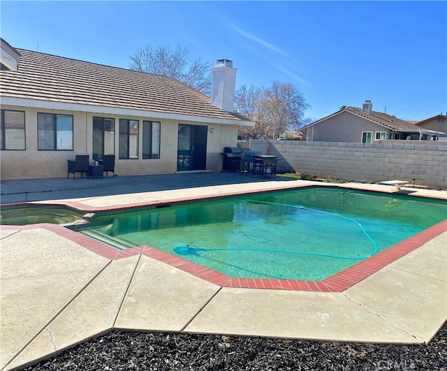 view of pool featuring a diving board and a patio