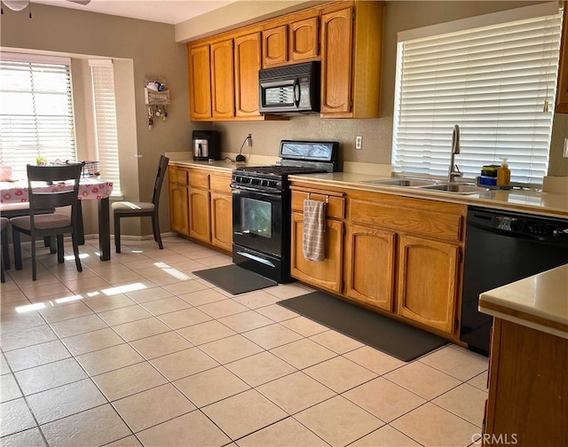 kitchen with sink, light tile patterned floors, and black appliances