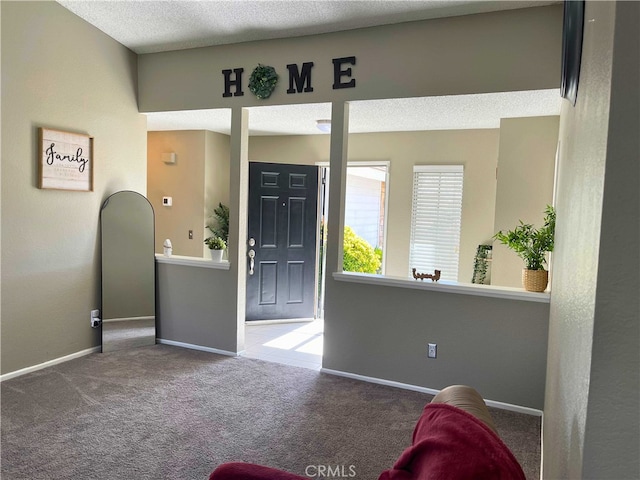 entryway featuring carpet flooring and a textured ceiling