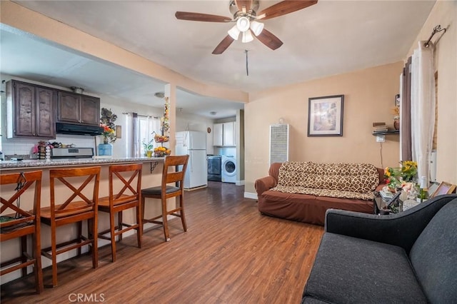 living room with washer / clothes dryer, hardwood / wood-style floors, and ceiling fan