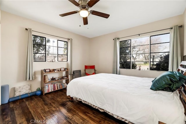 bedroom with ceiling fan, dark hardwood / wood-style floors, and multiple windows