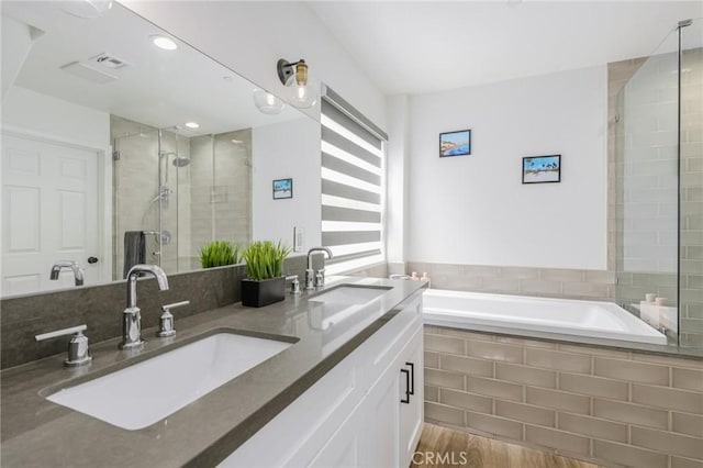 bathroom featuring vanity, hardwood / wood-style floors, and plus walk in shower