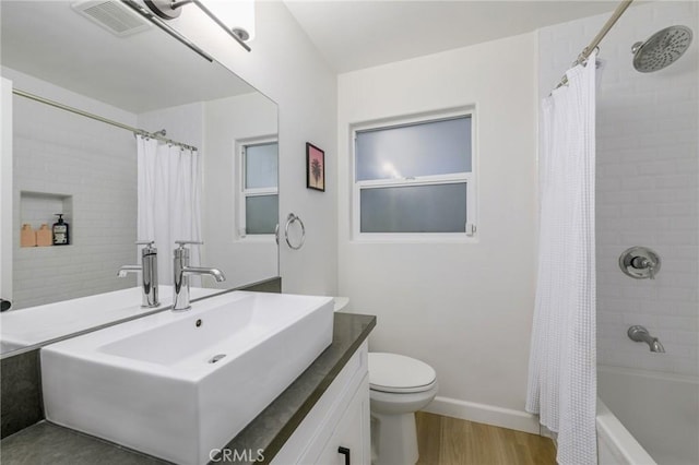 full bathroom featuring vanity, hardwood / wood-style flooring, shower / bath combination with curtain, and toilet