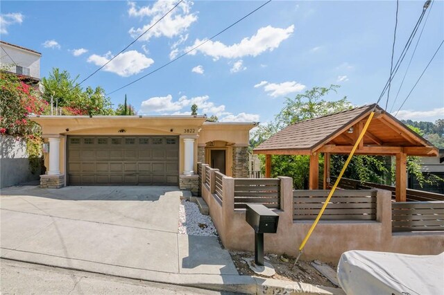 3822 Clayton Ave, Los Angeles, CA 90027 - view of front of property featuring an attached garage, fence, stone siding, and driveway