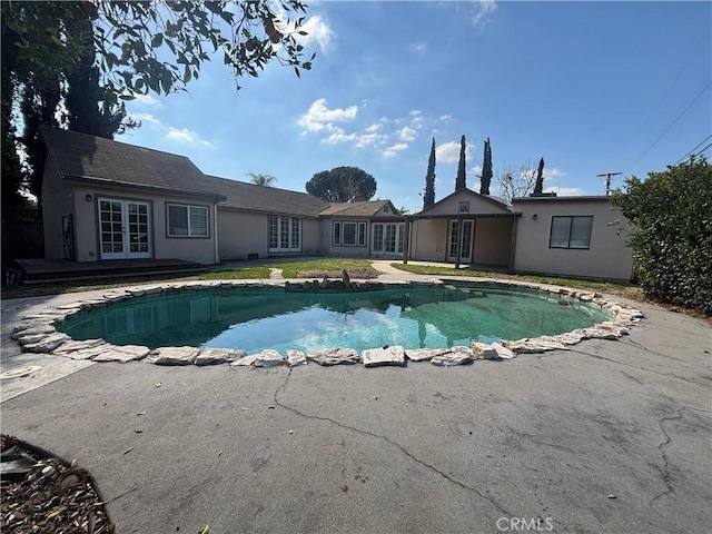 view of swimming pool featuring french doors