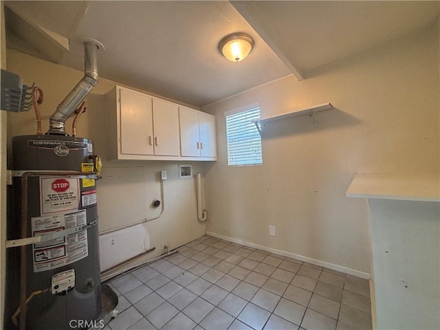 clothes washing area with light tile patterned floors, gas water heater, and cabinets