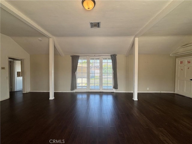 spare room featuring lofted ceiling and dark hardwood / wood-style floors