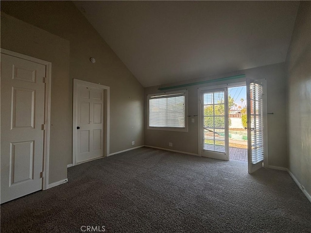 carpeted empty room featuring high vaulted ceiling