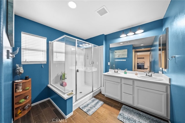 bathroom with vanity and a shower with door