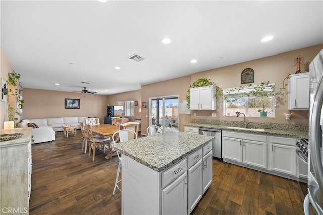 kitchen featuring appliances with stainless steel finishes, a center island, sink, and white cabinets