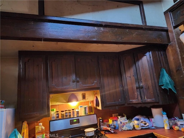 kitchen featuring dark brown cabinets and tile counters