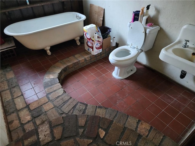 bathroom with a bath, tile patterned floors, and toilet