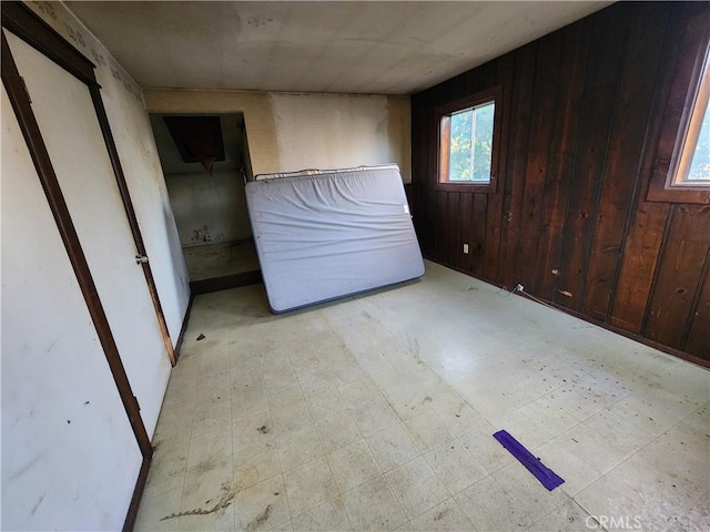 unfurnished bedroom featuring wood walls