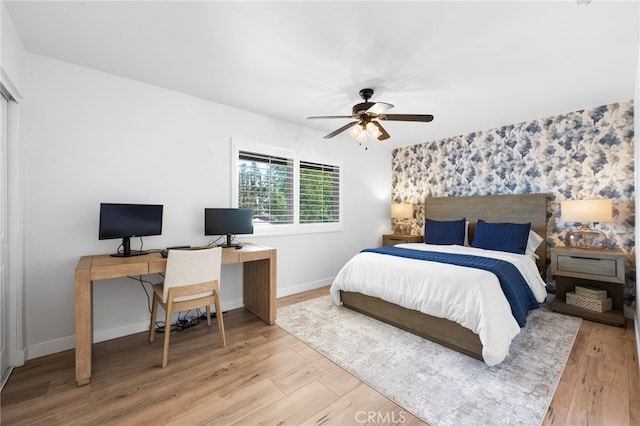 1320 W Fern Ave, Redlands, CA 92373 - bedroom featuring an accent wall, wallpapered walls, light wood-style flooring, and baseboards