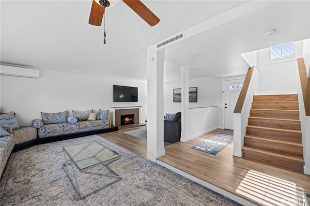 1320 W Fern Ave, Redlands, CA 92373 - living area with a wall unit AC, visible vents, ceiling fan, wood finished floors, and stairs