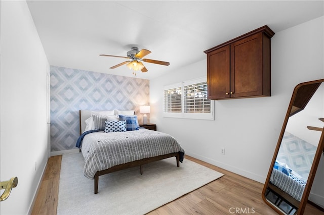 1320 W Fern Ave, Redlands, CA 92373 - bedroom featuring light wood finished floors, an accent wall, wallpapered walls, and baseboards