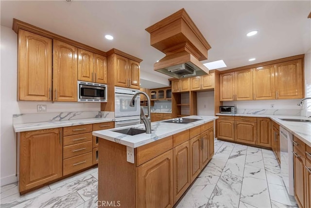 kitchen featuring white appliances, sink, and a center island with sink