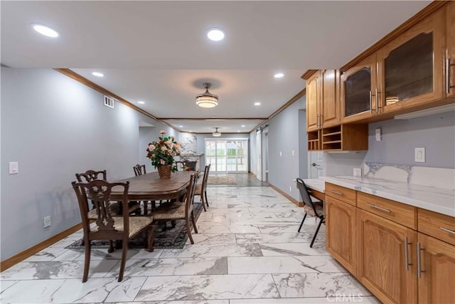 dining space featuring built in desk and ornamental molding