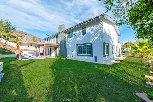 rear view of property featuring a lawn and a patio