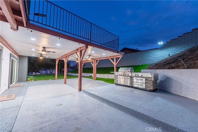 patio at twilight featuring an outdoor kitchen and grilling area