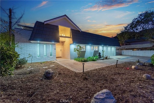 back house at dusk with a patio