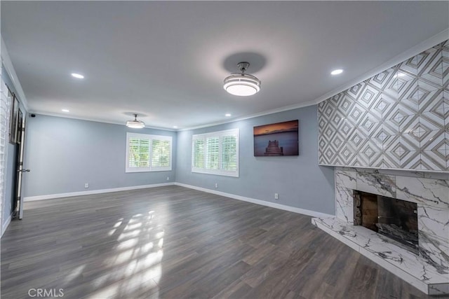 unfurnished living room featuring ornamental molding, a high end fireplace, and dark hardwood / wood-style floors